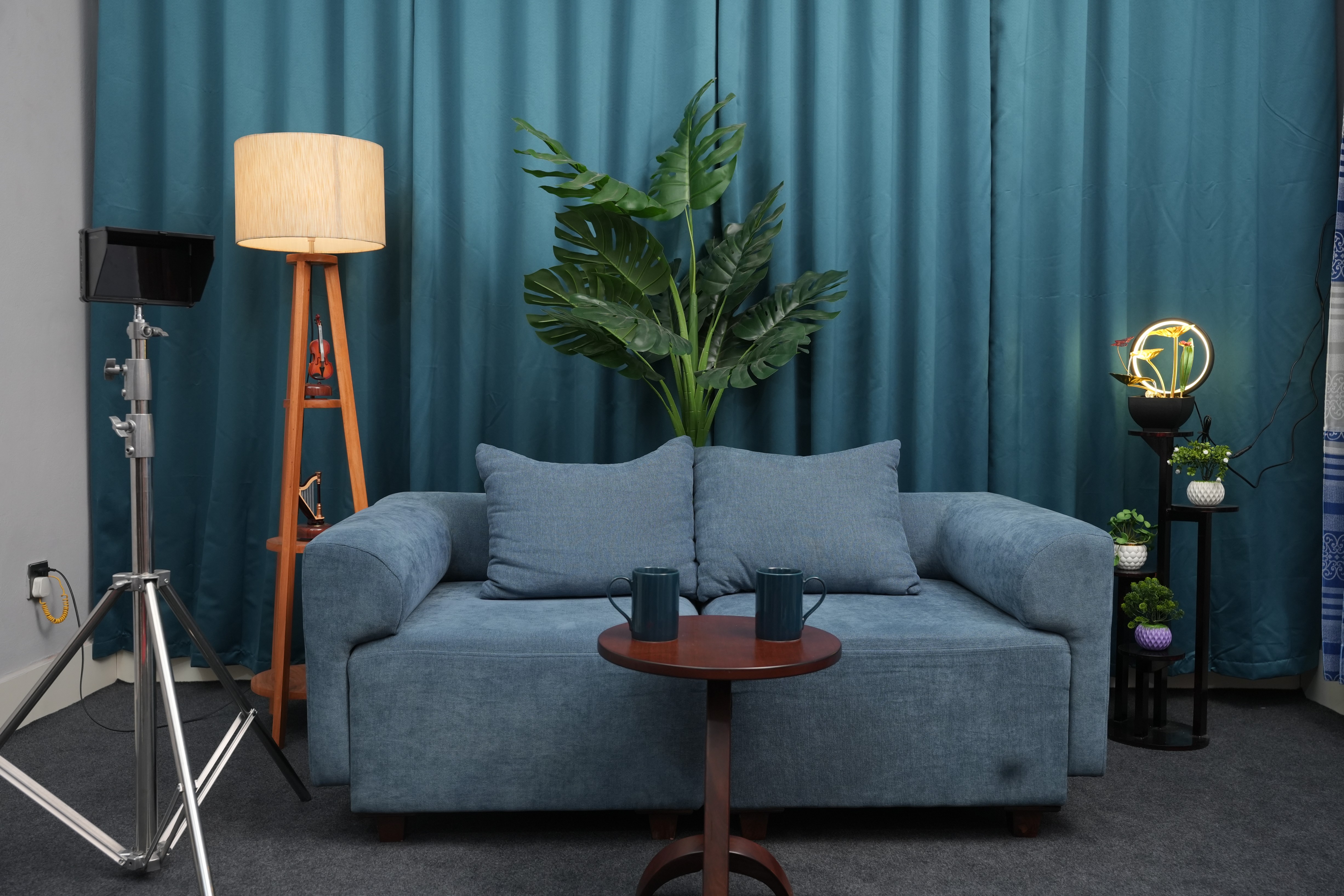 PlatiRoll studio set with teal curtain backdrop, sofa and styled decor