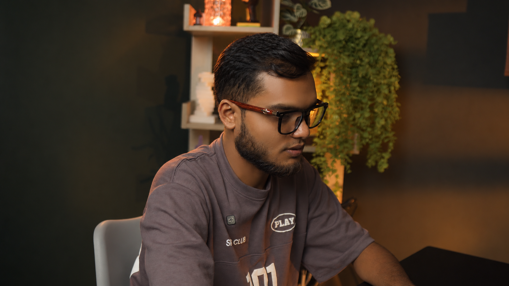 Person seated in the PlatiRoll studio, shot close-up with soft background lighting and plants
