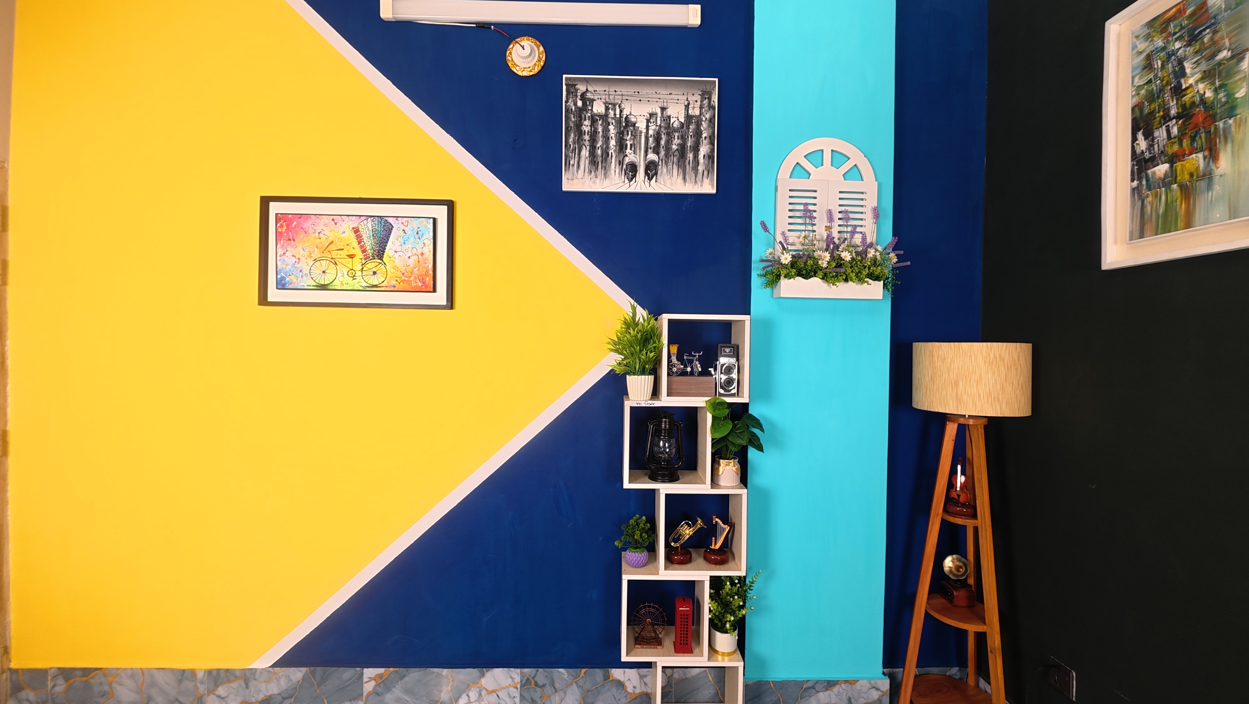 Bright PlatiRoll studio wall in yellow, navy and turquoise with framed art, decor shelves and a floor lamp